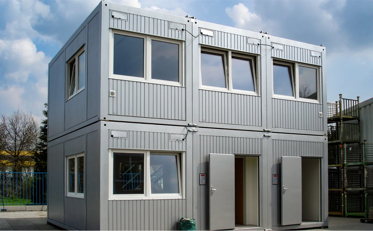 Zweigeschossige Containeranlage mit großzügigen Fenstern und mehreren Zugängen