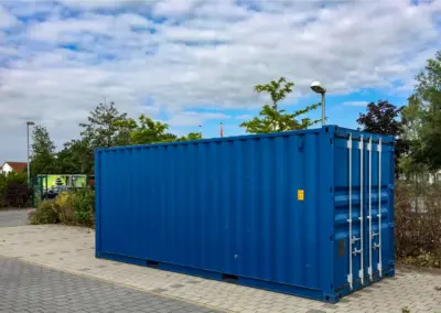 Großer blauer Lagercontainer seitlich geschlossen, aufgestellt auf befestigter Fläche.